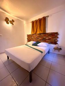 1 dormitorio con 1 cama en una habitación con ventana en Kapumati Villa - Évasion en Martinique en Sainte-Anne