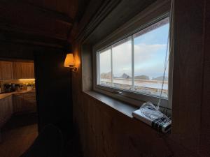 ein Fenster in einem Zimmer mit Blick auf den Strand in der Unterkunft Ingrid Rorbu, Å i Lofoten in Å + 32 Fotos