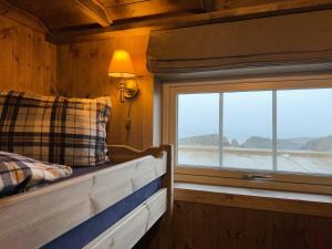 a bedroom with a bed and a window with a view at Ingrid Rorbu, Å i Lofoten in Å