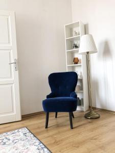 een blauwe stoel in een kamer naast een lamp bij City Center Apartments Bratislava in Bratislava