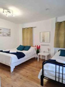 a bedroom with two beds and two tables in it at Nice Flat near Central London in London