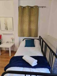 a bedroom with a bed with a mirror and a window at Nice Flat near Central London in London