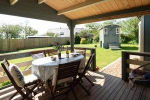 a patio with a table and chairs on a deck at Safari Cornwall in Bodmin