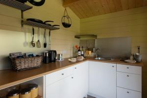 a kitchen with white cabinets and a counter top at Safari Cornwall in Bodmin