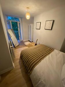 a bedroom with a bed in a room with a window at Bowie's Abode in Sowerby Bridge