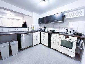 a kitchen with white cabinets and a black counter top at Apartment Scandic Living in Bautzen