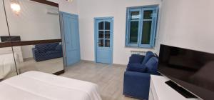 a living room with a blue chair and a tv at CASA CASCIOTTO in Palermo