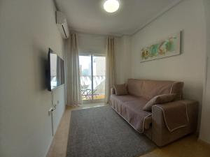 ein Wohnzimmer mit einem Sofa und einem TV in der Unterkunft Olga`s Apartments, 300 Meter zu Playa del Cura in Torrevieja