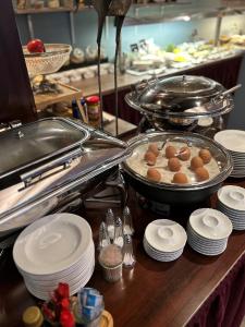 a kitchen with plates and dishes on a counter at Parkhotel Papenburg in Papenburg