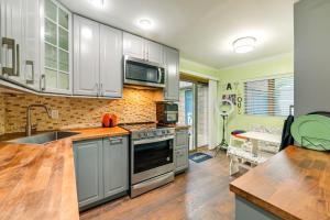 uma cozinha com um lavatório e um fogão forno superior em Long Island Home with Deck, Yard, 5 Mi to Beach! em Farmingdale