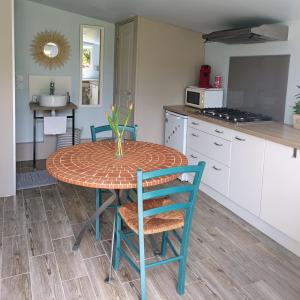 kuchnia ze stołem i krzesłami w kuchni w obiekcie Le Petit Accent w mieście Saint-Pierre-de-Bailleul