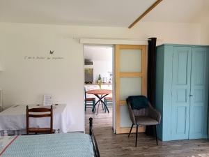 Saint-Pierre-de-Bailleul的住宿－Le Petit Accent，一间设有蓝色橱柜和桌椅的房间
