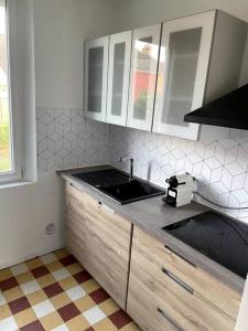 - une cuisine avec un évier et un comptoir dans l'établissement Maison de charme proche centre-ville, à Dieppe