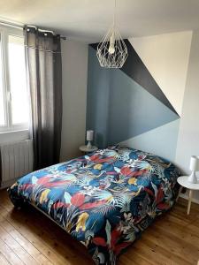 ディエップにあるMaison de charme proche centre-villeのベッドルーム1室(カラフルな毛布付きのベッド1台付)