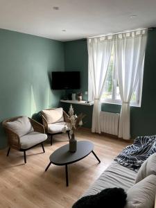 sala de estar con sofá, sillas y mesa en Maison de charme proche centre-ville en Dieppe