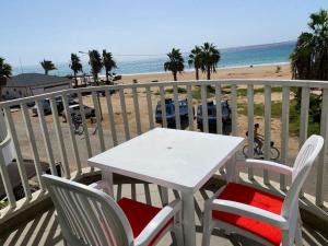 een witte tafel en stoelen op een balkon met uitzicht op het strand bij Leme Bedje Sea View Apartments with Pool in Santa Maria