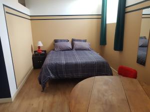 a bedroom with a bed and a table in it at COSA SARA in Niort