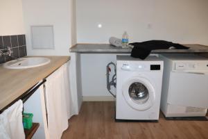 a kitchen with a washing machine and a sink at COSA SARA in Niort +2 photos