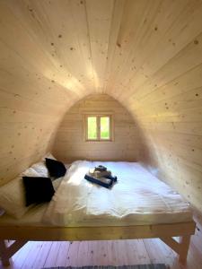 a bed in a wooden room with a window at Merineitsi metsamaja in Tahkuna