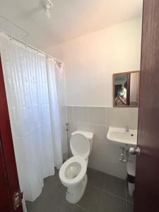 a bathroom with a toilet and a sink at Montierra Subdivision Staycation CDO in Cagayan de Oro