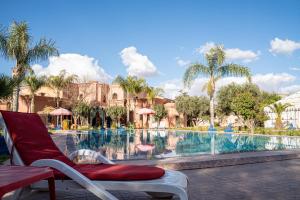 a chair next to a pool at a resort at Las Palmeras Guest House in Marrakesh