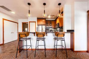 a kitchen with a bar with stools in it at Blackstone Mountain Lodge by CLIQUE in Canmore