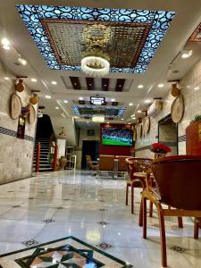a restaurant with a table and chairs and a ceiling at Dar Al Salaam Hospitality House in Nizwa