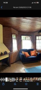 una sala de estar con sofá en una habitación con ventanas en toda paz do universo, en Nova Friburgo