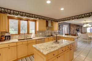 a kitchen with wooden cabinets and granite counter tops at Waterfront Luna Pier Home 14 Mi to Downtown Toledo in Erie