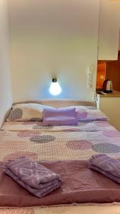 a large bed with purple pillows on top of it at Apartments Neven in Omiš