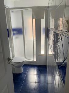 ein Badezimmer mit WC und zwei Fenstern in der Unterkunft Playa del Puntal I Villaviciosa Primera Linea Playa in Villaviciosa