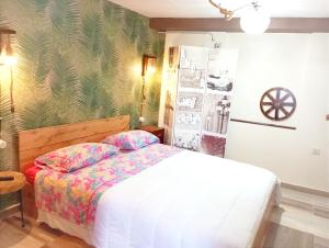 um quarto com uma cama branca e um papel de parede verde em IL Vicoletto em Serra San Bruno