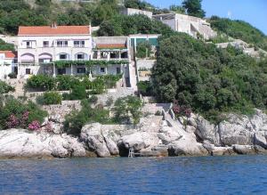 a building on a hill next to the water at Apartments Bajo - FREE PARKING in Dubrovnik