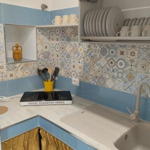 - une cuisine avec des carreaux bleus et blancs et un évier dans l'établissement Junno Maison Doli', à Mattinata