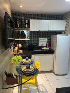 a kitchen with a yellow table and a refrigerator at Pipas Ocean in Pipa