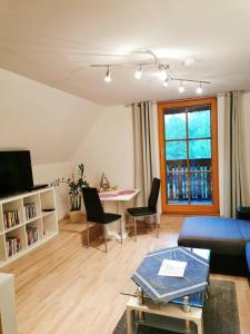 ein Wohnzimmer mit einem blauen Sofa und einem Tisch in der Unterkunft Pension Treissmann in Pichling bei Stainz