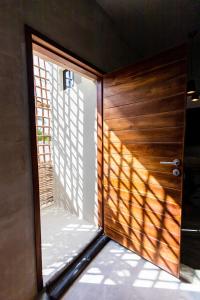 uma porta de madeira com uma janela num quarto em Hotel Siesta Holbox em Holbox