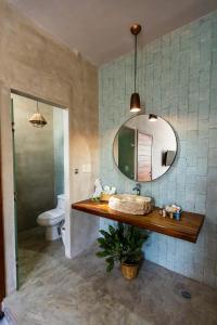 a bathroom with a sink and a mirror and a toilet at Hotel Siesta Holbox in Holbox Island