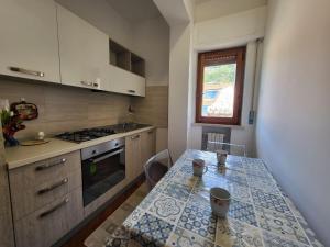 a small kitchen with a table and a stove at Appartamenti Orchidea in Tropea