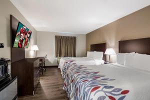 a hotel room with two beds and a flat screen tv at Red Roof Inn Allentown South in Allentown