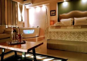 um quarto com uma cama, uma mesa e uma televisão em Queen Boutique Suites Preveza em Preveza
