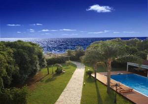 a resort with a swimming pool next to the ocean at Queen Boutique Suites Preveza in Preveza