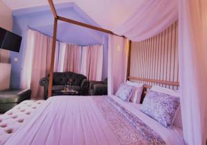 a bedroom with a large bed with a canopy at Queen Boutique Suites Preveza in Preveza +37 photos