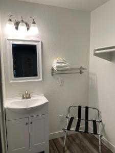 a bathroom with a sink and a mirror and a chair at Premier Inns Thousand Oaks in Thousand Oaks