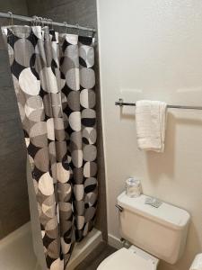 e bagno con servizi igienici e tenda per la doccia. di Premier Inns Thousand Oaks a Thousand Oaks