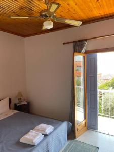a bedroom with a bed and a ceiling fan at Aglaia's traditional house in Ayía Kiriakí