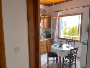 a small kitchen with a table and a window at Aglaia's traditional house in Ayía Kiriakí