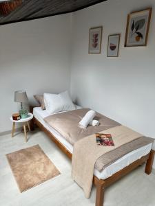 a white bedroom with a bed and a table at Mira's Apartment in Križevci