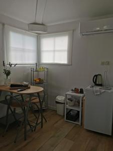 a small kitchen with a table and a small refrigerator at Apartment Maslina in Vrboska