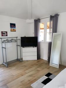 ein Wohnzimmer mit einem Flachbild-TV und einem Spiegel in der Unterkunft Apartment Maslina in Vrboska
